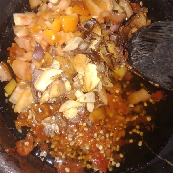 Lalu siramkan ke dalam cobek berisi cabai dan tomat.