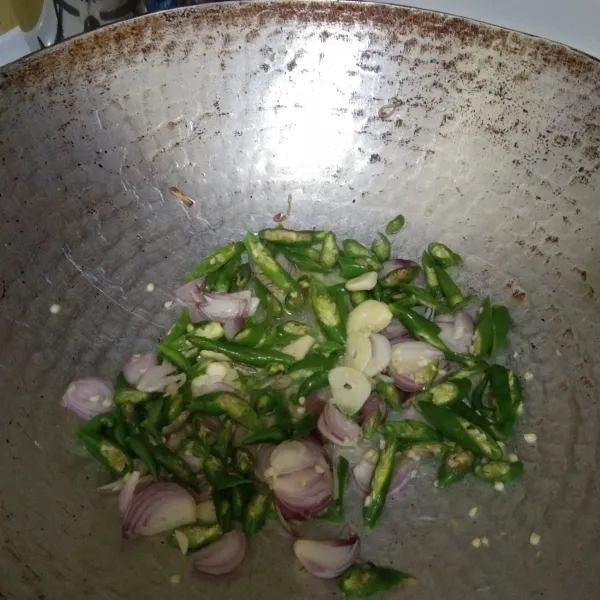 tumis irisan bawang putih, bawang merah dan cabe hijau keriting hingga harum