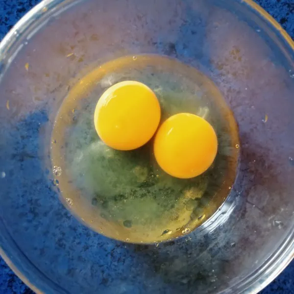 Pecahkan dua butir telur dalam mangkuk