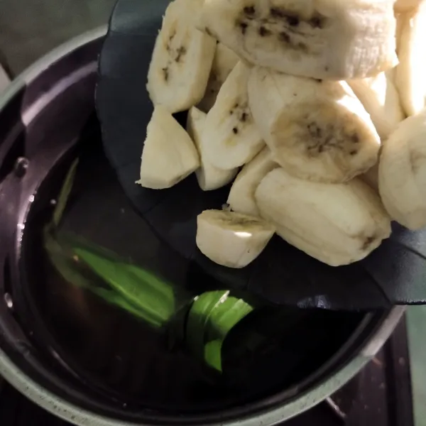 Didihkan air dan gula serta daun pandan. Setelah mendidih, masukkan pisangnya, didihkan sampai mendidih.