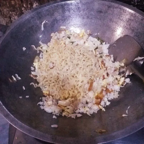 Masukkan nasi dan mie, aduk rata. Mie sambil dipotong kecil agar mudah tercampur dengan bahan lain