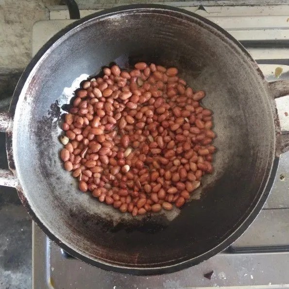 Gorenga kacang dengan minyak hingga kecokalatan atau matang.