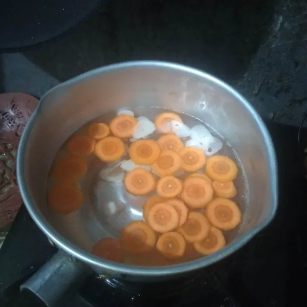 Didihkan air, masukkan wortel dan bawang putih. Masak hingga wortel setengah empuk.