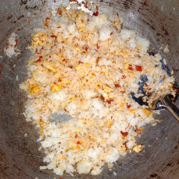 Masukkan nasi, bumbui dengan garam, lada dan kaldu bubuk, aduk rata.