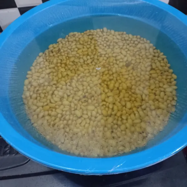 Cuci bersih kacang kedelai lalu siram dengan air panas dalam baskom atau panci, tutup selama 8 jam.