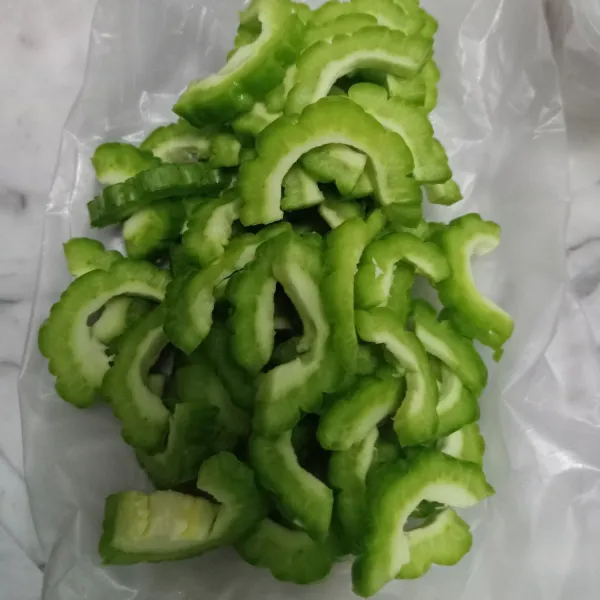 Lalu iris-iris sekitar 1 ruas jari. Lalu taburi garam dan remas-remas, diamkan beberapa menit. Lalu bilas dan tiriskan (ini biar menghilangkan getah dan tidak terlalu pahit parianya).