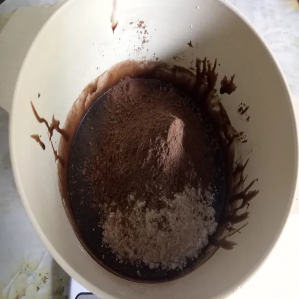 Setelah itu masukan tepung terigu, coklat bubuk, baking powder lalu aduk sampai rata.