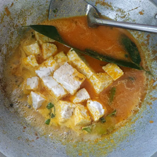 Setelah matang, tambahkan 300 ml air, cabe rawit utuh, tempe dan daun salam. Masak hingga mendidih.