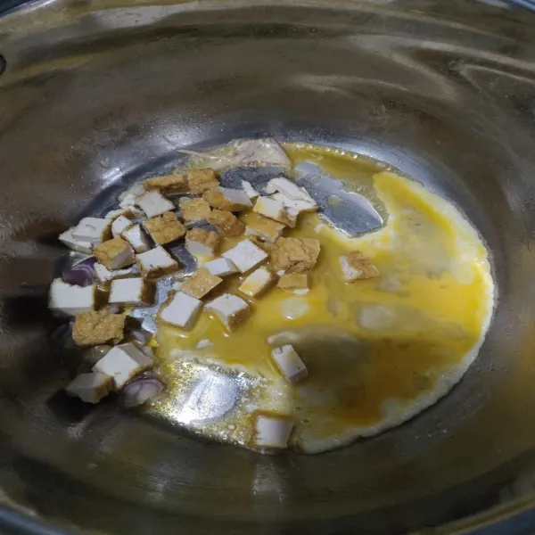 Masukkan mentega lalu bawang merah, telur dan tahu diaduk merata hingga matang.