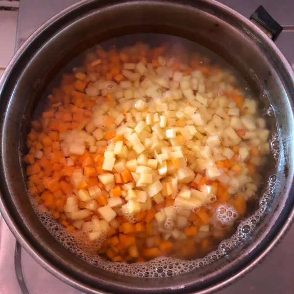 Potong dadu kecil wortel dan kentang. Rebus hingga setengah matang, lalu ngkat dan tiriskan.