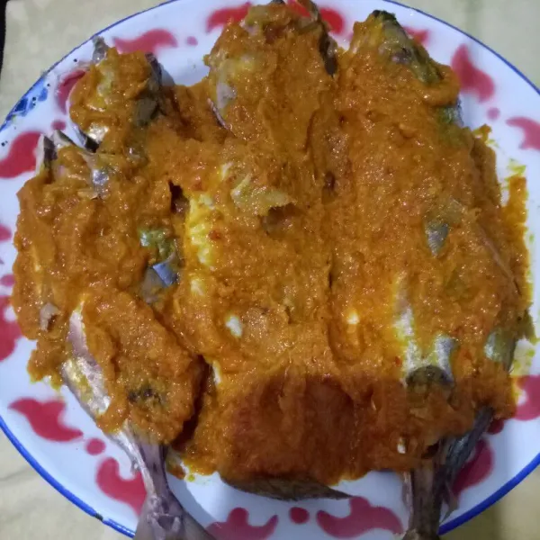 Tuang bumbu ke atas ikan dan ratakan ke seluruh permukaan ikan.