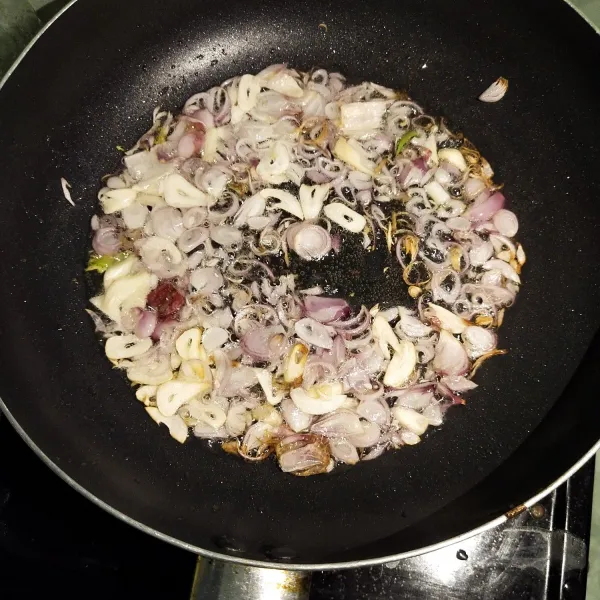 Goreng bawang merah dan bawang putih sampai harum.