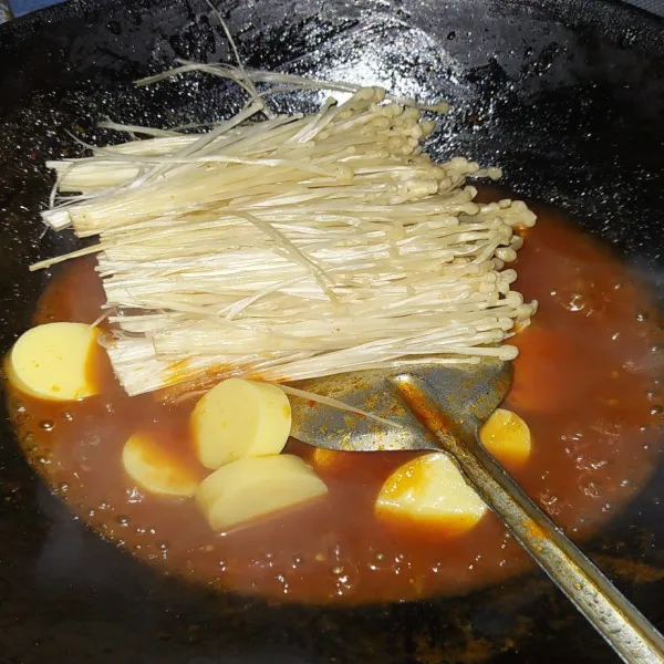 Masukkan potongan tofu dan jamur enoki. Masak hingga keduanya matang.