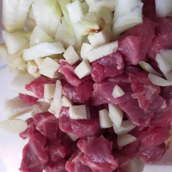 Potong bawang bombay dan daging sapi kecil-kecil supaya mudah digiling.