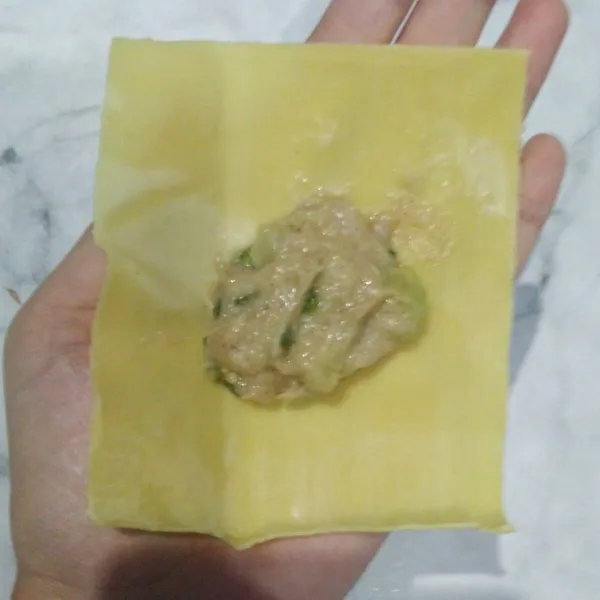 Siapkan kulit pangsit. Masukkan isian ke dalamnya.