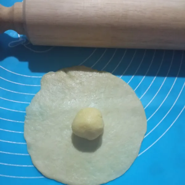 Gilas water dough lalu letakan oil dough diatasnya , tutup jadi bulatan