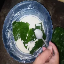 Masukkan beberapa bayam kedalam tepung, lumuri bayam menggunakan sendok.