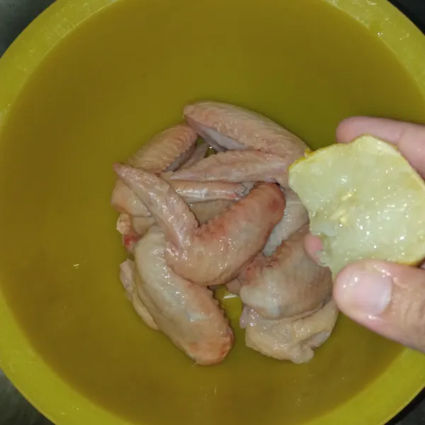 Cuci bersih sayap ayam, beri perasan air lemon. Dimakan 30 menit, bilas lalu tiriskan.