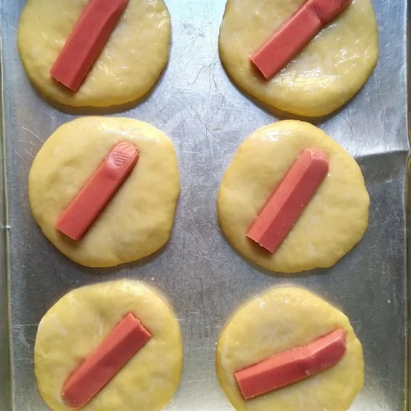 Beri larutan susu. Oleskan menggunakan kuas. Beri sosis.