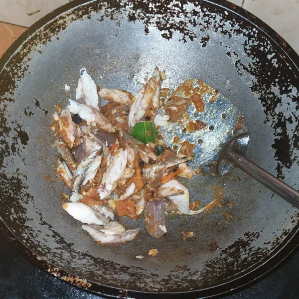 Panaskan secukupnya minyak lalu tumis bumbu halus dau jeruk, serai dan lengkuas sampai matang, lalu masukkan air dan ikan.