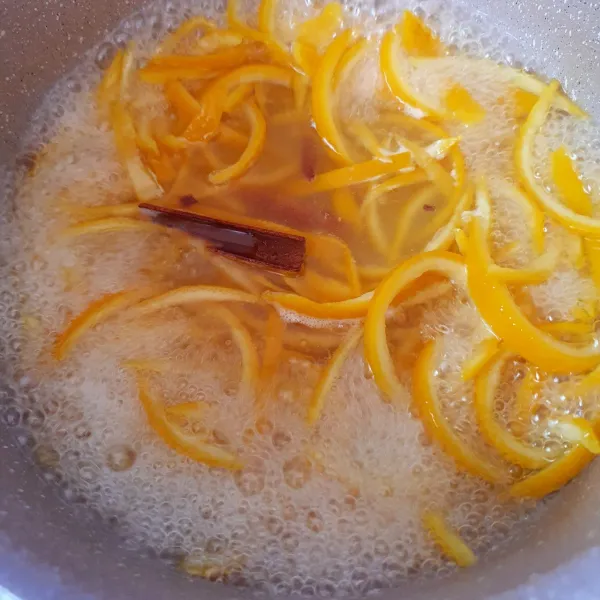 Panaskan 100 ml air bersama gula, tambahkan kayu manis dan cengkeh. Masukkan kulit jeruk. Tambahkan air jeruk lemon. Masak hingga menyusut dan mengental.