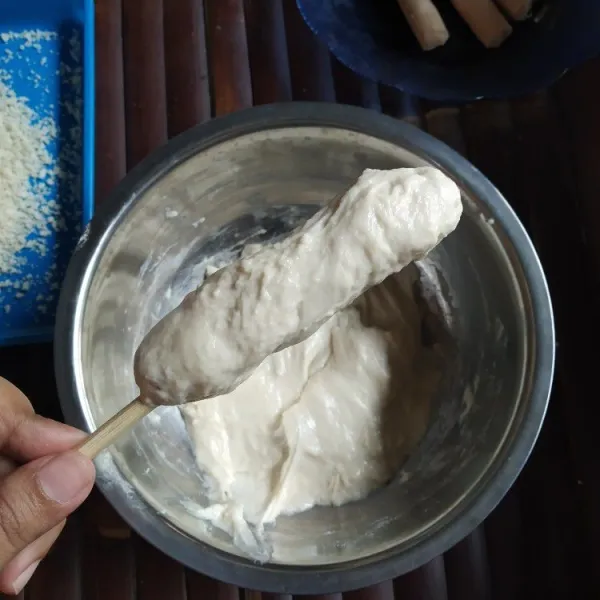 Baluri sosis dengan adonan menggunakan bantuan pisau hingga semua tertutup rata.