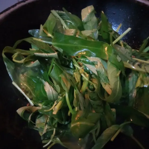 Masukkan kangkung, aduk rata. Masak hingga layu.