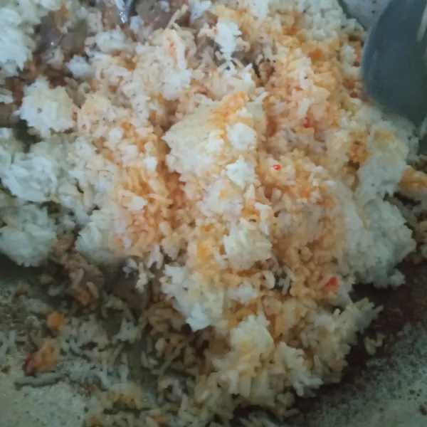 Masukkan nasi, aduk rata, tambahkan garam dan kaldu jamur secukupnya, koreksi rasa. Jika sudah pas, matikan api. Nasi goreng siap disajikan.