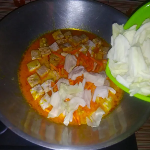 Masukkan tempe, wortel dan daun kol. Aduk rata. Tambahkan garam, kaldu bubuk dan gula. Aduk rata dan masak hingga tempe matang dan wortel lunak. Koreksi rasa dan matikan api.