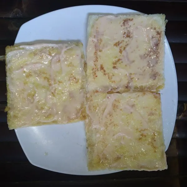 Campur rata mayonaise dan saus sambal dalam mangkok, oleskan pada roti tawar.