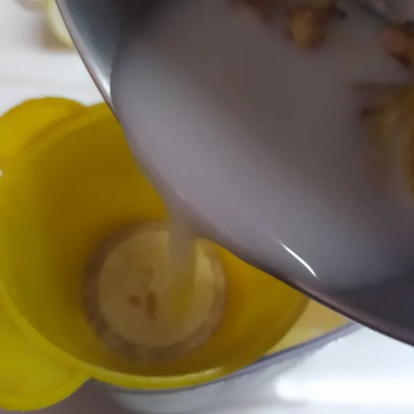 Tuang rebusan susu yang mendidih sambil disaring ke dalam campuran kuning telur dan madu.