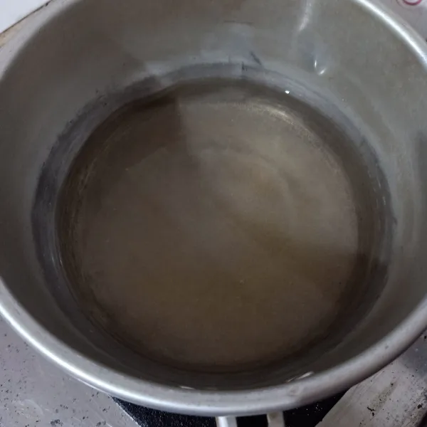 Rebus air dan gula sambil diaduk, cukup sampai gula larut (tidak perlu mendidih), lalu biarkan panasnya hilang.