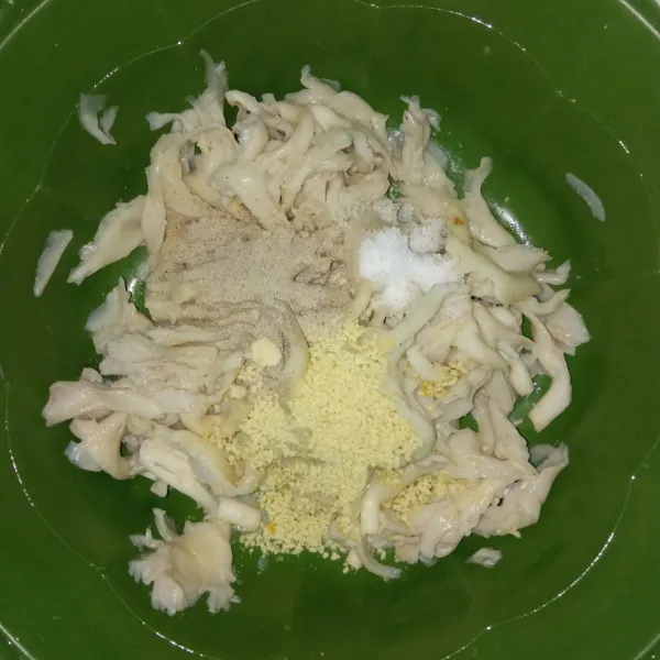 Taruh jamur tiram suwir ke dalam wadah. Tambahkan garam, lada bubuk dan kaldu jamur lalu remas2 sampai bumbu meresap dan tercampur rata.