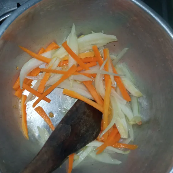 Panaskan sedikit minyak. Tumis bawang putih cincang, bombay dan wortel hingga lunak.