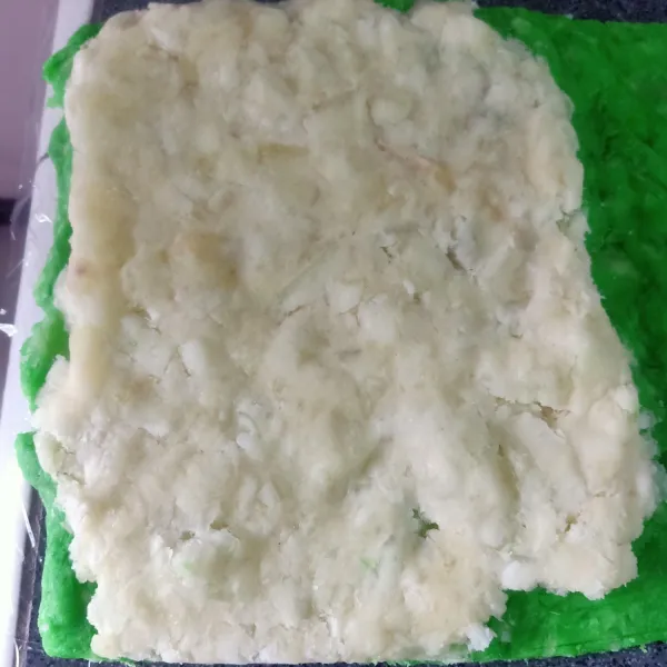 susun adonan getuk hijau dibawah lalu masukan adoan putih diatasnya ratakan.