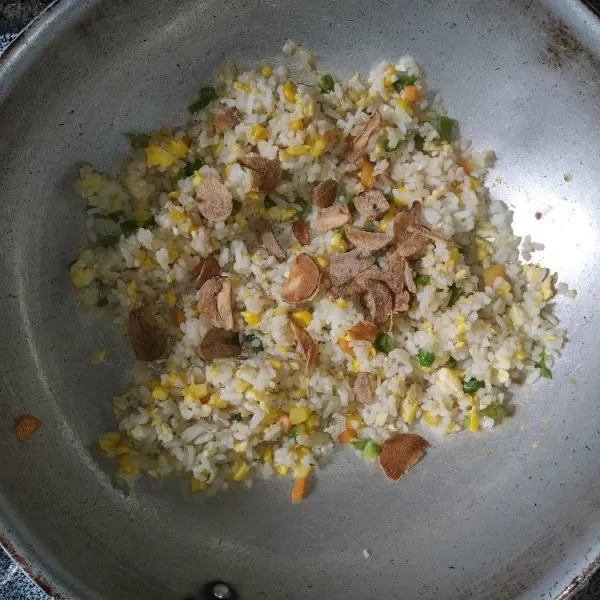 Tambahkan sebagian bawang putih goreng, aduk rata.