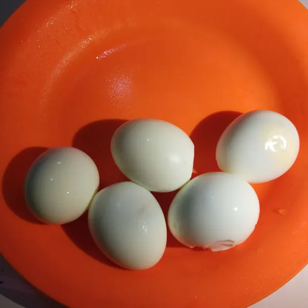 Rebus telur hingga matang dan kelupas kulitnya.