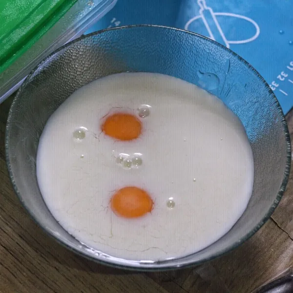 Kocok susu cair, whipping cream dan kuning telur di mangkok.