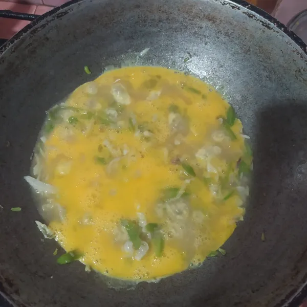 Setelah sayuran empuk, masukkan telur yang sudah dikocok. Biarkan sampai bawahnya hampir matang, orak-arik perlahan.