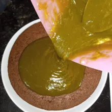 Tuang topping di atas cake pisang hingga seluruh permukaan cake rata