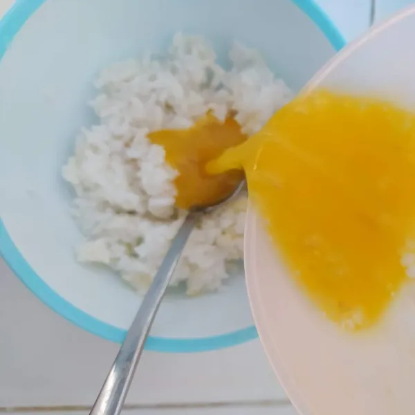 Pecahkan 1 butir telur, tambahkan ½ sdt bawang putih bubuk, ¼ sdt garam, ¼ sdt merica bubuk dan ¼ sdt kaldu jamur, kocok lepas. Kemudian tuang ke dalam nasi sisa, aduk rata.
