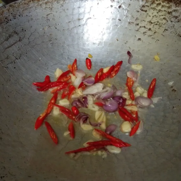 Tumis irisan bawang putih, bawang merah, dan cabe merah keriting hingga harum.