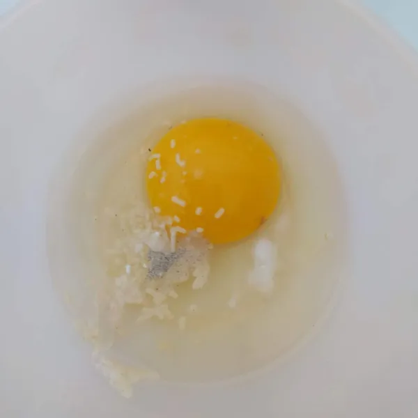 Di mangkok lain pecahkan telur, bumbui dengan ½ sdt bawang putih bubuk, ¼ sdt garam, ¼ sdt merica bubuk dan ¼ sdt kaldu jamur, kocok lepas.