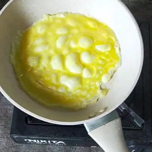 Lelehkan margarin dalam wajan datar, tuang 1 sendok sayur adonan telur. Masak sambil diputar wajannya. Masak hingga habis kira kira 4 lapis omelet.