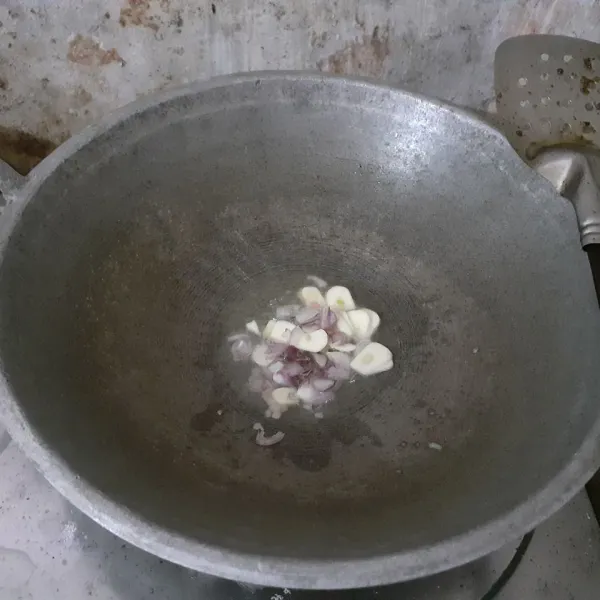 Tumis irisan bawang merah dan bawang putih dalam minyak panas hingga harum.