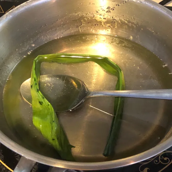 Dalam panci masak air, gula dan sehelai daun pandan dengan api kecil. Aduk hingga gula larut dan biarkan dingin.