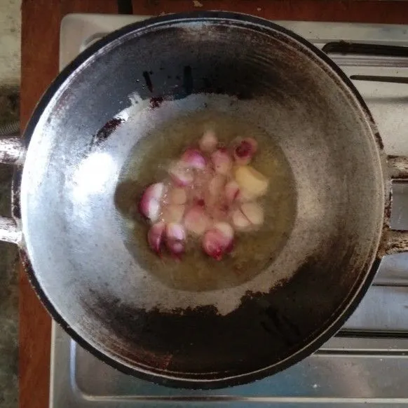 Goreng bawang merah, bawang putih dan cabe rawit yang telah dibersihkan dan diiris dengan minyak goreng.