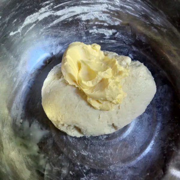 Masukkan mentega dan garam, uleni kembali hingga kalis elastis.