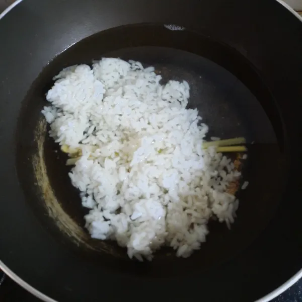 Didihkan air dan serai dalam wajan. Masukkan nasi dan garam. Aduk rata. (Catatan: Jika menggunakan labu kuning dan ubi, di step ini ikut dimasukkan. Sebaiknya sudah dikukus dahulu agar matang bersamaan dengan nasi).