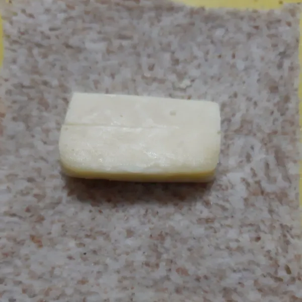 Tata keju mozarella di ½ bagian roti. Beri putih telur ke sekeliling pinggir roti. Lipat sisi kiri kanan ke tengah. Rapikan sambil ditekan-tekan